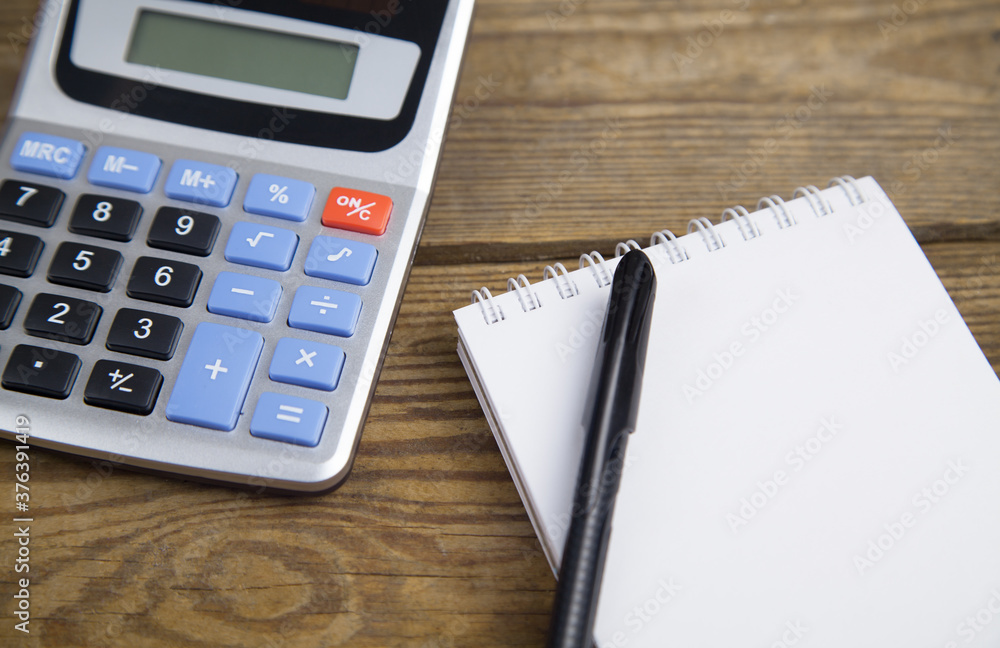 Notebook, pen and calculator isolated on wooden background. Notebook, pen and calculator isolated on wooden background.