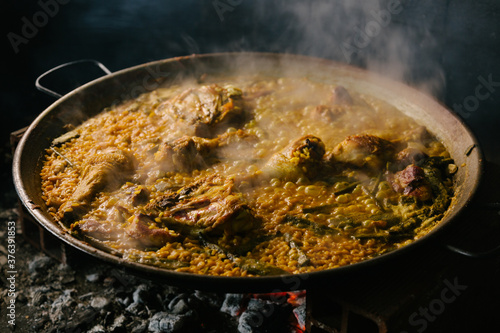 cooking a paella over a wood fire. Valencia Spain photo
