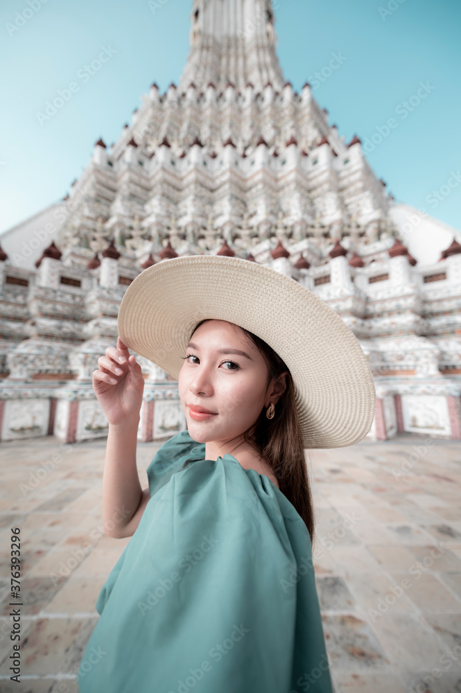 Young Asian woman is enjoy sightseeing and traveling at Wat Arun temple in Bangkok, Thailand.