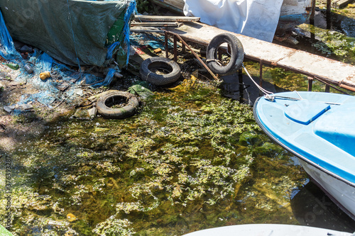 Used car tires remained in nature. The old unnecessary tire of car remained in the water. The problem of recycling waste, garbage, environmental pollution The environmental problem of waste management