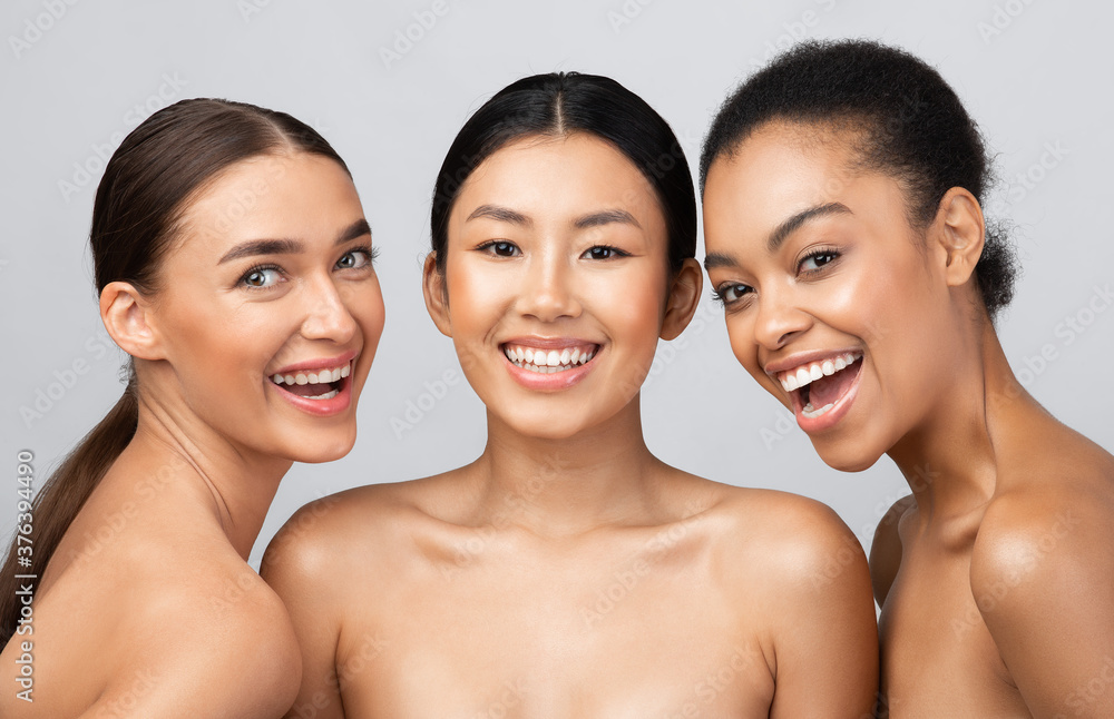 Three Joyful Models Girls Posing Smiling To Camera, Studio Shot Three Joyful Models Girls Posing Smiling To Camera, Studio Shot