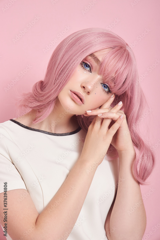 Cute girl with long pink hair, hair coloring. Beautiful woman on a pink background in a white dress. Colored hair, perfect hairstyle, beauty and care Cute girl with long pink hair, hair coloring. Beautiful woman on a pink background in a white dress. Colored hair, perfect hairstyle, beauty and care