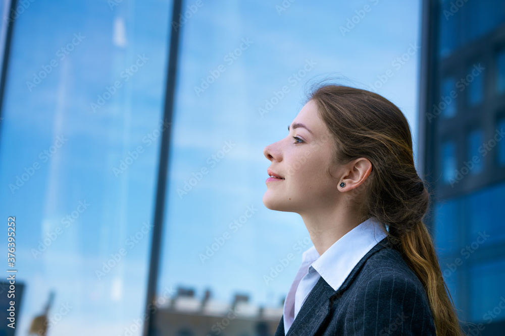 The girl stands sideways against the background of business center. The girl stands sideways against the background of business center.