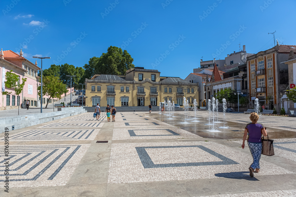 View at the central piazza in Chaves downtown city, with a people walking on, Chaves library as background