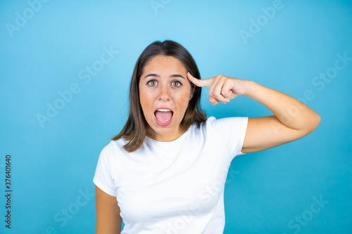 Young beautiful woman over isolated blue background smiling and thinking with her fingers on her head that she has an idea.