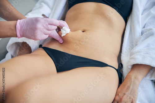 Doctor in latex gloves preparing a female for an injection