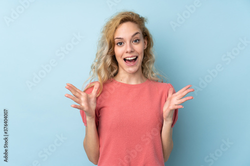 Young blonde woman isolated on blue background with surprise facial expression © luismolinero