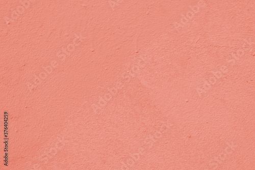 Peach wall of the building. Rough plaster surface. Abstract background.