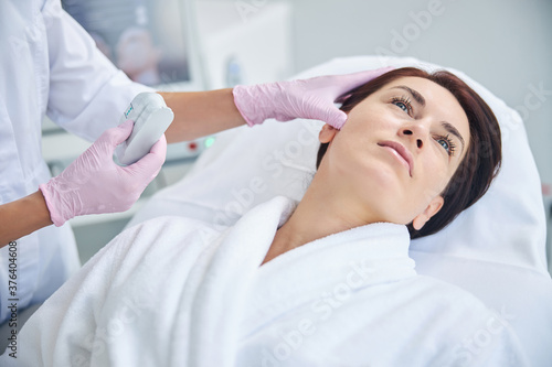 Calm pensive woman staring up during the skin check