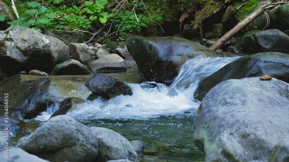 Small Waterfall on Mountain River With Clear Babbling Water From the Huge Stones Small Waterfall on Mountain River With Clear Babbling Water From the Huge Stones