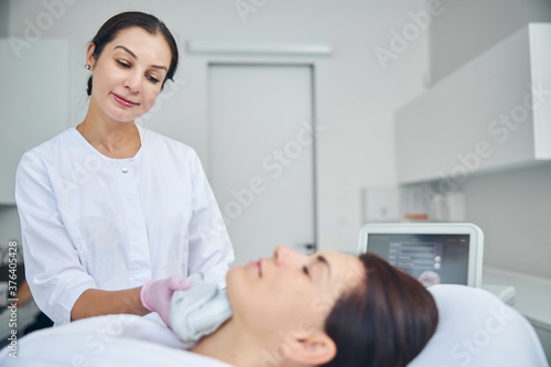 Doctor looking at her patient during a cosmetic procedure