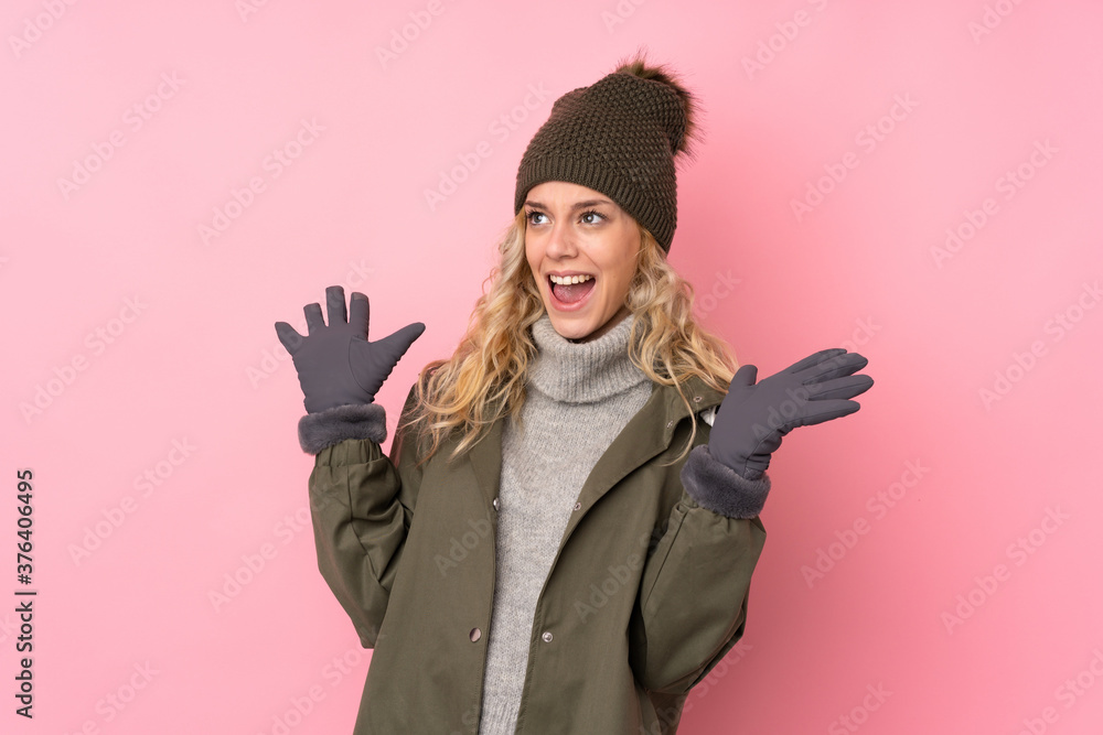 Young girl with winter hat isolated on pink background with surprise facial expression Young girl with winter hat isolated on pink background with surprise facial expression