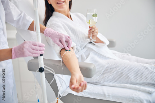 Smiling female patient undergoing intravenous vitamin therapy photo