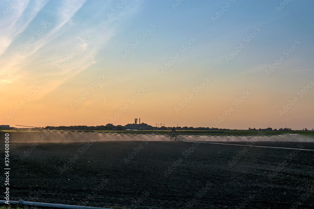 Fototapeta premium Watering the fields at dusk