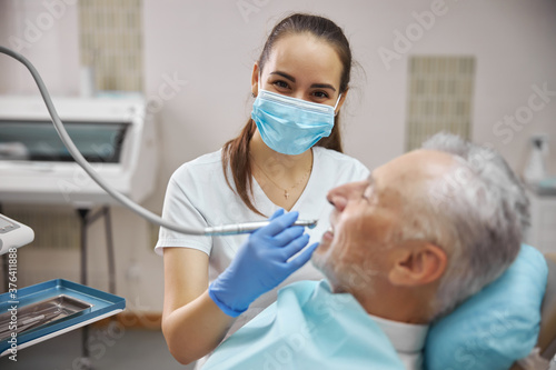 Fototapeta Naklejka Na Ścianę i Meble -  Beautiful female dentist in the middle of a dental procedure