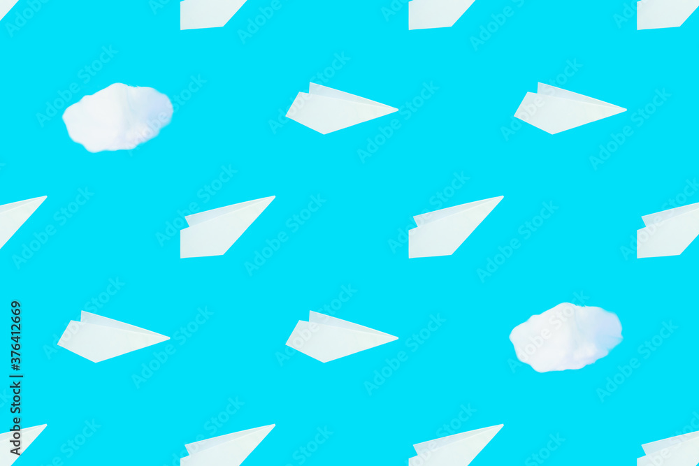 Pattern from white paper airplanes and cotton clouds on a blue background. Creative concept of travel, flights.. Pattern from white paper airplanes and cotton clouds on a blue background. Creative concept of travel, flights..