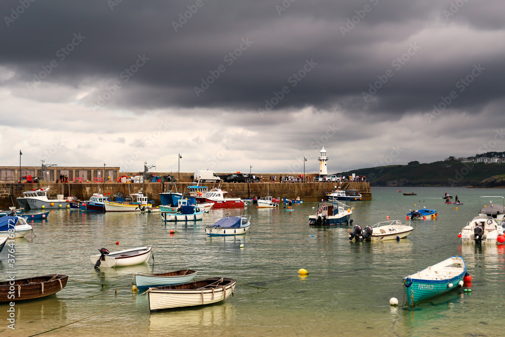 Boats in St Ives Harbor, Cornwall, with storm clouds rolling in
