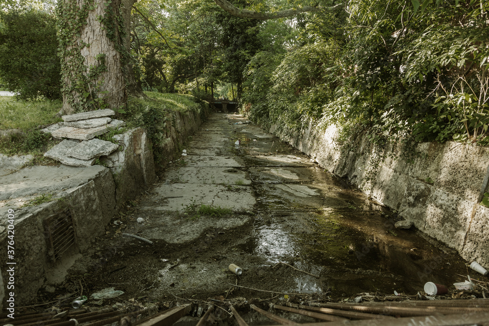 Obraz premium City Canal Drainages to prevent floods. Concrete drainage channel for the transportation of sewage during heavy rains and floods coming from the mountains. Urban sewer collector