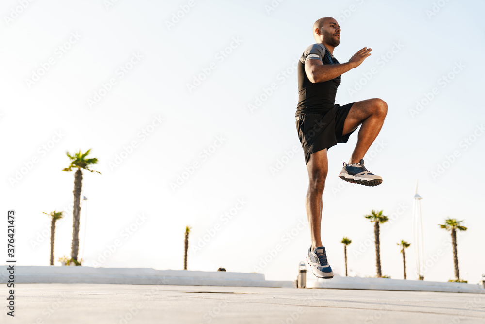 Image of african american sportsman doing exercise while working out