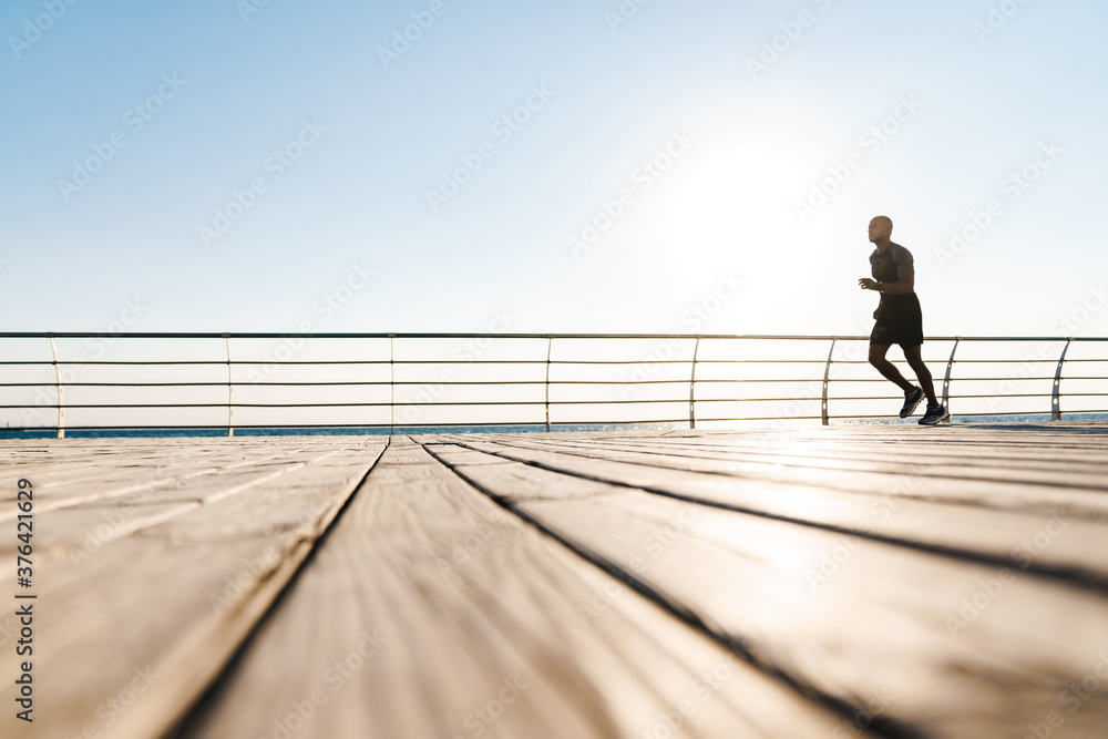 Image of athletic african american sportsman running while working out