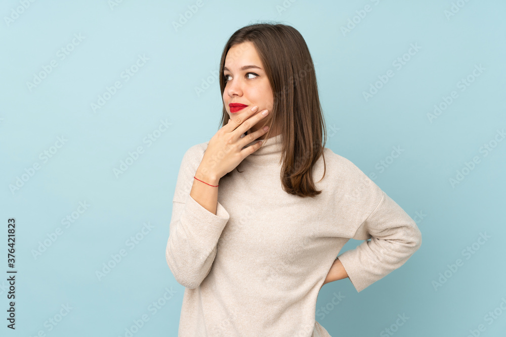 Teenager girl isolated on blue background thinking an idea Teenager girl isolated on blue background thinking an idea