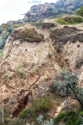 Landslide zone on Black Sea coast. Rock of sea rock shell. Zone of natural disasters during rainy season. Large masses of earth slip along slope of hill, destroy houses. Landslide - threat to life