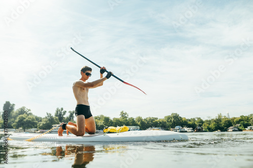 Athlete trains on a sup board, swims on the river and paddles. Surfing on the sup board as a hobby.