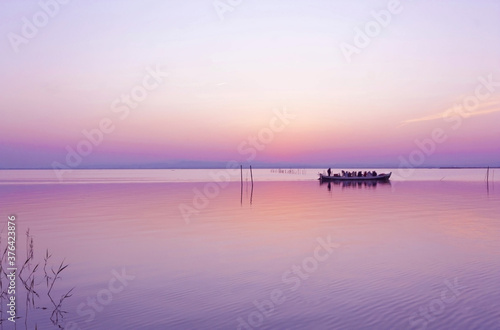 Pinks views. Some hikers take a boat ride on the Albufera lake in Valencia