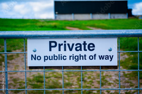 Private sign no public right of way on a farm with a view of a field