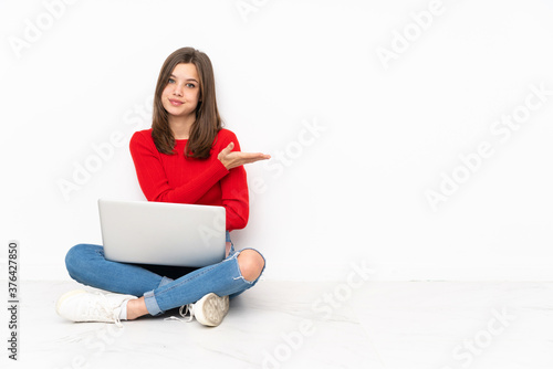 Tenaager girl working with pc isolated on white background presenting an idea while looking smiling towards