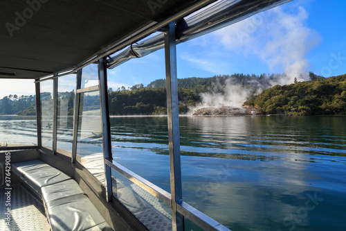 Steam rises from the Orakei Korako geothermal area  New Zealand  seen from an approaching boat 