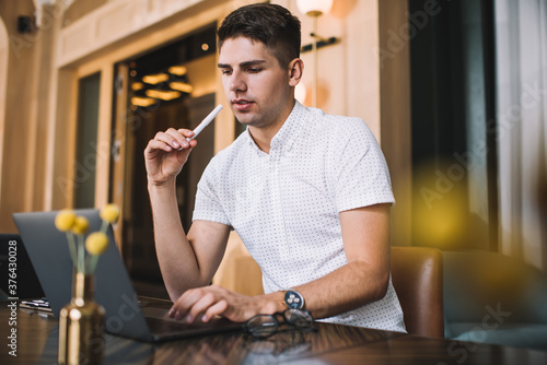 Pensive man using laptop in cafe