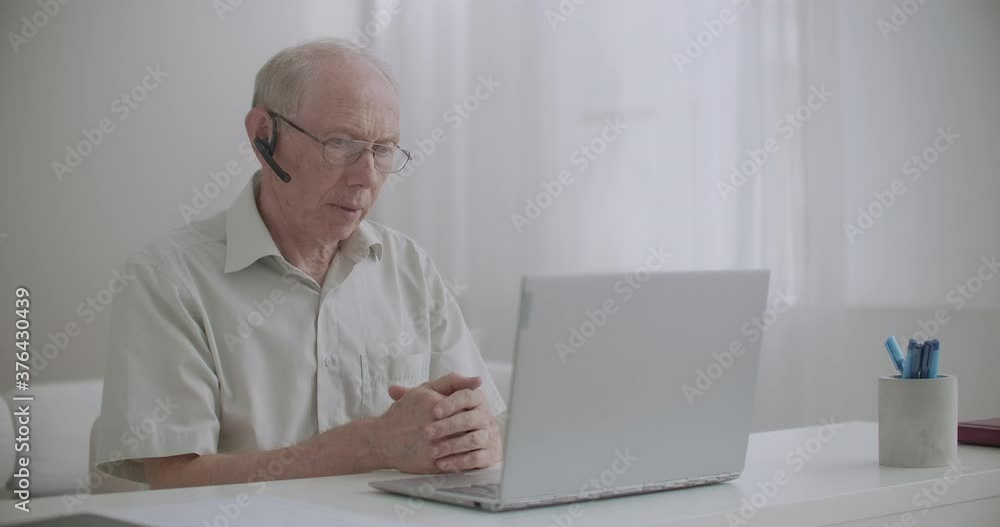 aged man is using video call on notebook, sitting at home, for communication with colleagues, self-isolating and remote working aged man is using video call on notebook, sitting at home, for communication with colleagues, self-isolating and remote working