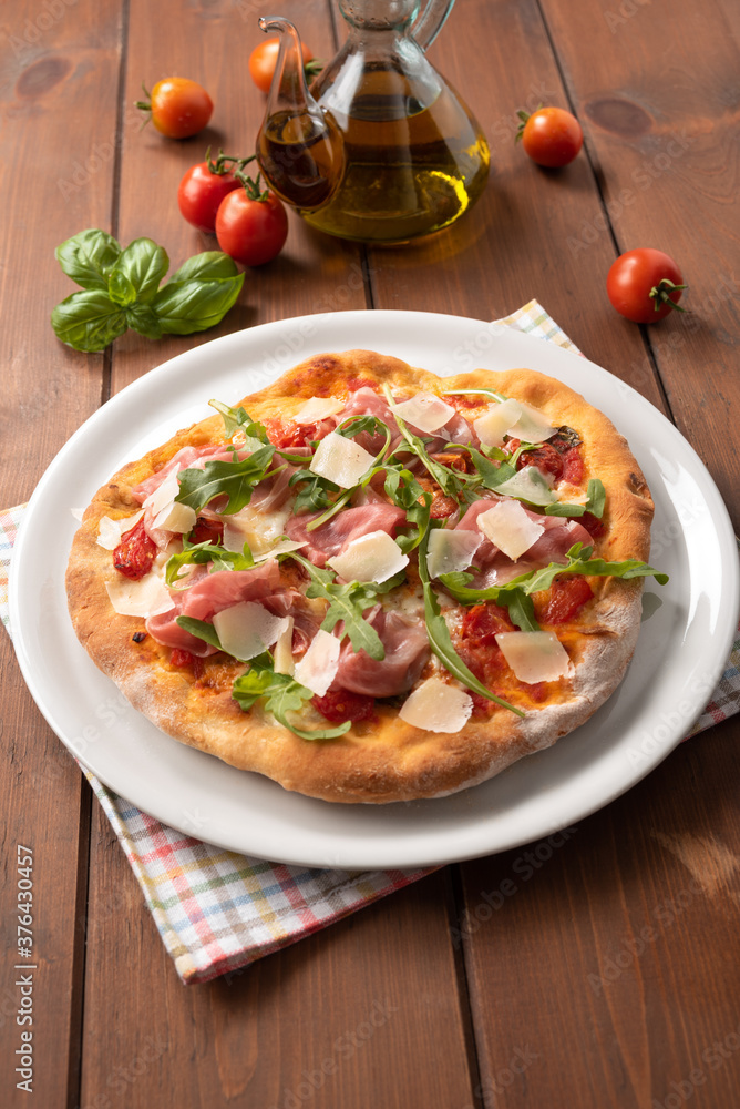 Deliziosa pizza con prosciutto crudo di Parma, rucola e scaglie di formaggio grana, Cucina Italiana