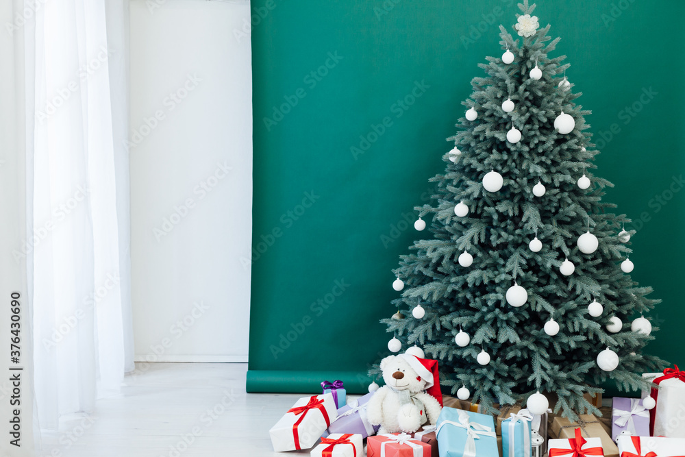 Fototapeta premium Interior with blue Christmas tree with gifts for new year decor winter postcard green background
