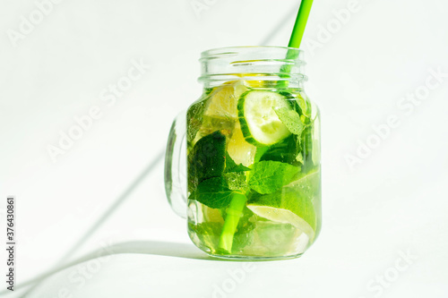 Health care, fitness, healthy nutrition diet concept. Fresh cool lemon cucumber mint infused water, cocktail, detox drink, lemonade in a glass jar.