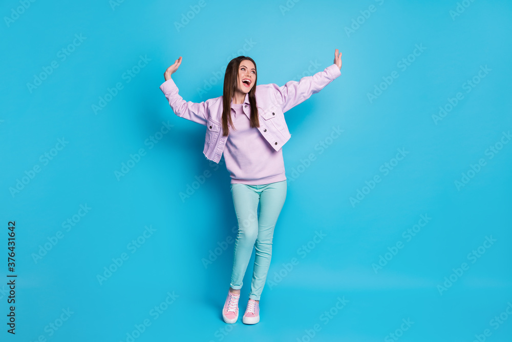Full body photo of enthusiastic content youth girl look copyspace move dance night club raise hands enjoy rejoice wear casual style clothes sneakers isolated over blue color background Full body photo of enthusiastic content youth girl look copyspace move dance night club raise hands enjoy rejoice wear casual style clothes sneakers isolated over blue color background