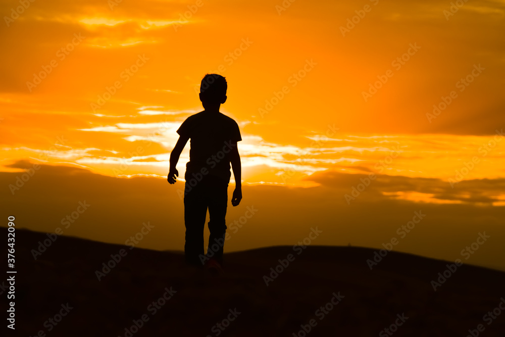 silhouette of a man standing on the top of the mountain