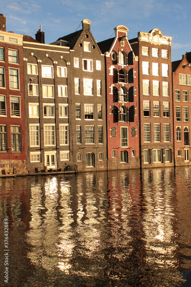 Romantisches Amsterdam; Häuserzeile am Damrak im Abendlicht