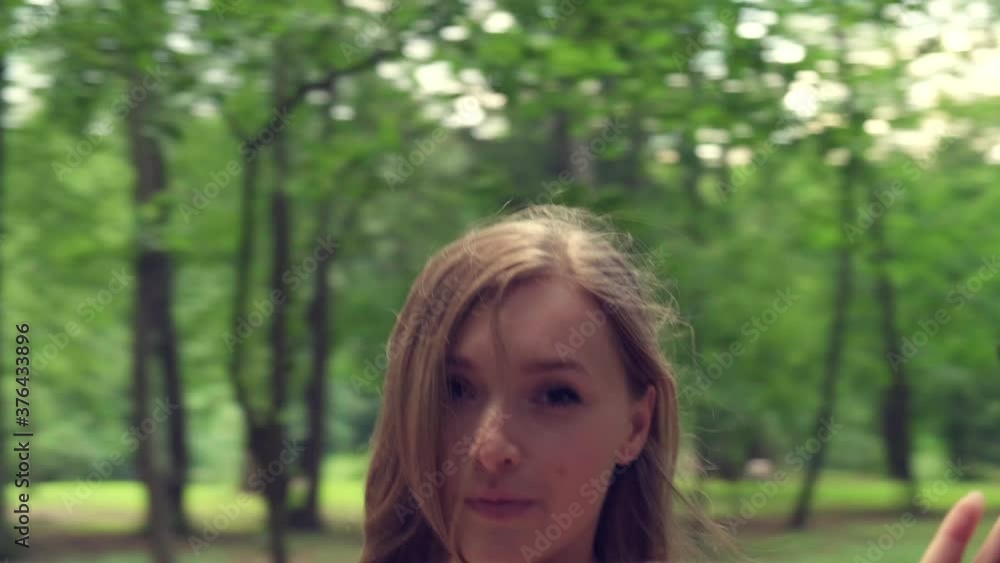 A beautiful young girl goes to a meeting and looks at the camera. The girl walks through the forest in summer. 4K video. A beautiful young girl goes to a meeting and looks at the camera. The girl walks through the forest in summer. 4K video.