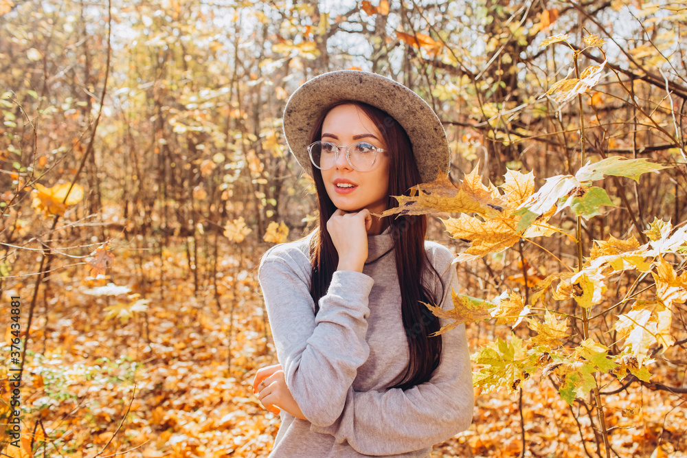 Portrait of a girl in a hat in an autumn park, a woman walks in the woods at sunset Portrait of a girl in a hat in an autumn park, a woman walks in the woods at sunset