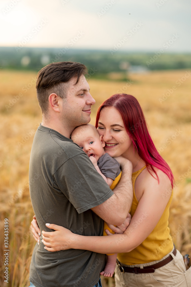 Father, mother and their little son have fun together in a wheat field. Father, mother and their little son have fun together in a wheat field.