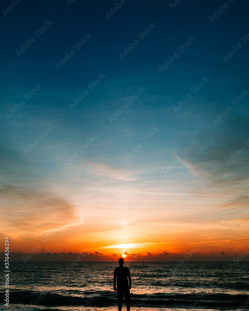 silhouette of a man on the beach at sunrise
