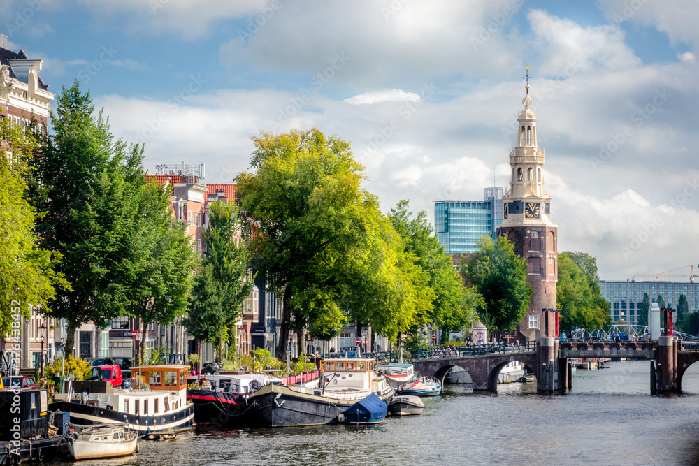 downtown Amsterdam with the Montelbaanstoren tower and péniche barges on a canal