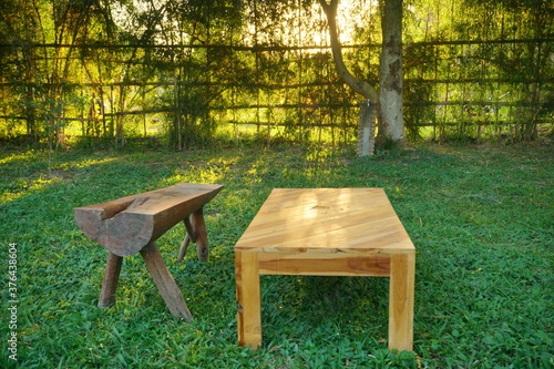 Wooden bench and table on a plain grass field.