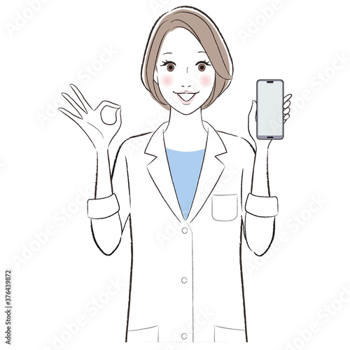 A woman doctor wearing lab coat smiling showing smart phone and ok sign.