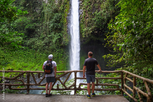 Two tourists looking at the La Fortuna Waterfall in Costa Rica