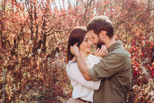 Portrait of a young couple in the autumn forest, a guy and a girl cuddling in the outdoor