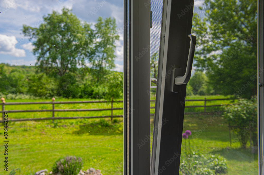 Fototapeta premium plastic window in the house is open for ventilation on a sunny day.