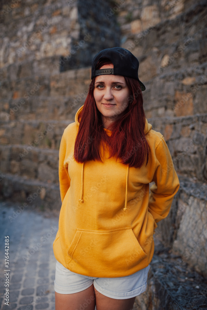 City portrait of handsome beautiful plus size girl wearing casual yellow blank hoodie or sweatshirt with space for your logo or design. Mockup for print City portrait of handsome beautiful plus size girl wearing casual yellow blank hoodie or sweatshirt with space for your logo or design. Mockup for print